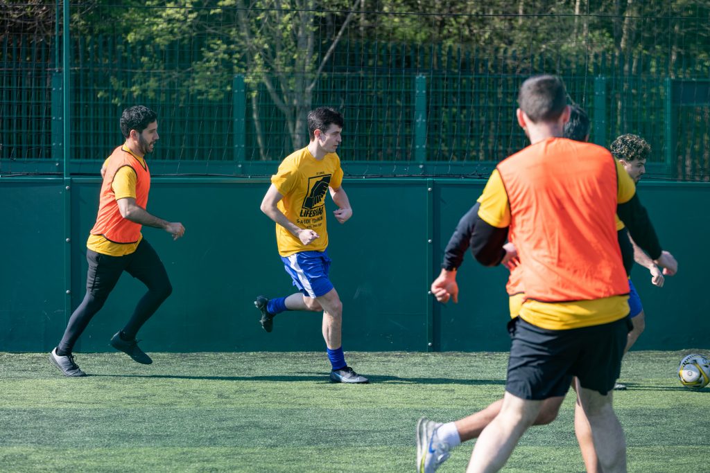 Charity football tournament players in yellow shirts and bibs