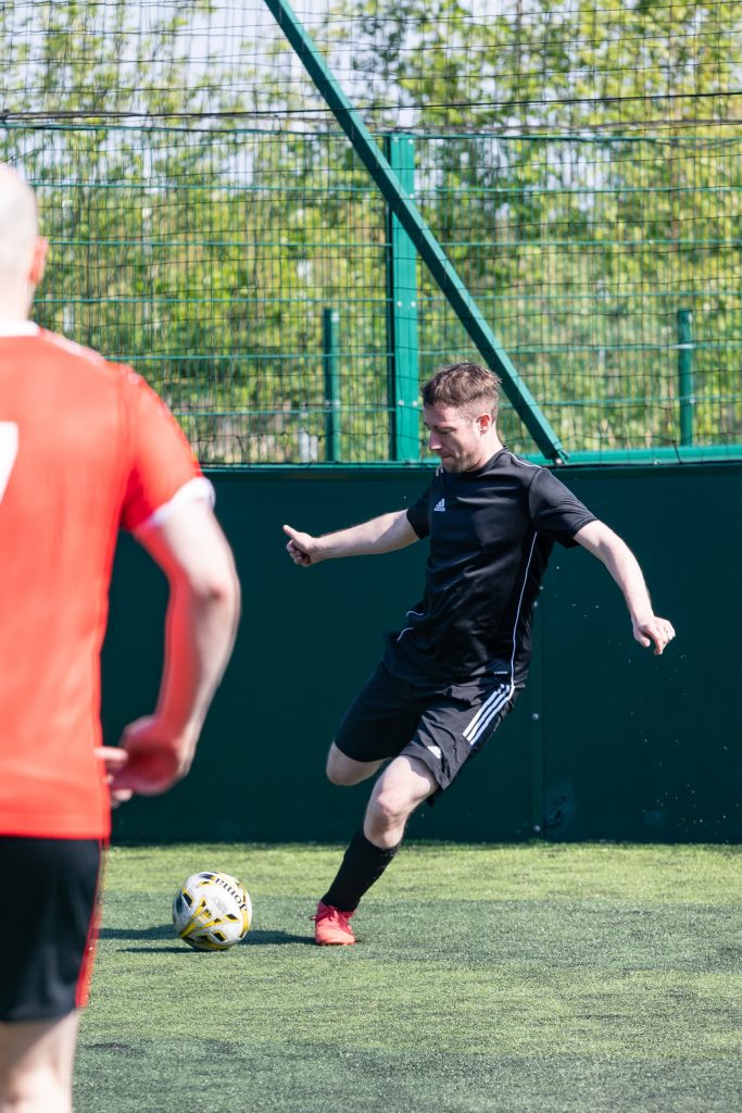 man in black kit playing charity football