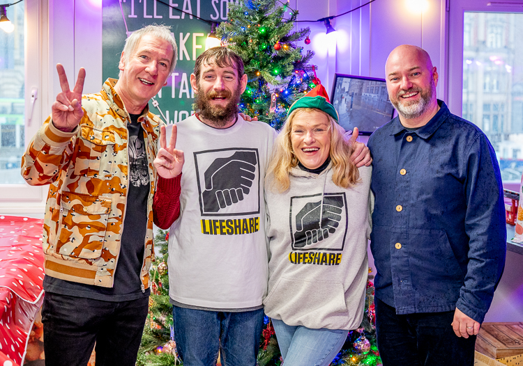 Clint Boon, Stephen Agnew, Judy Vickers, and Matt Legg in front of a Christmas Tree
